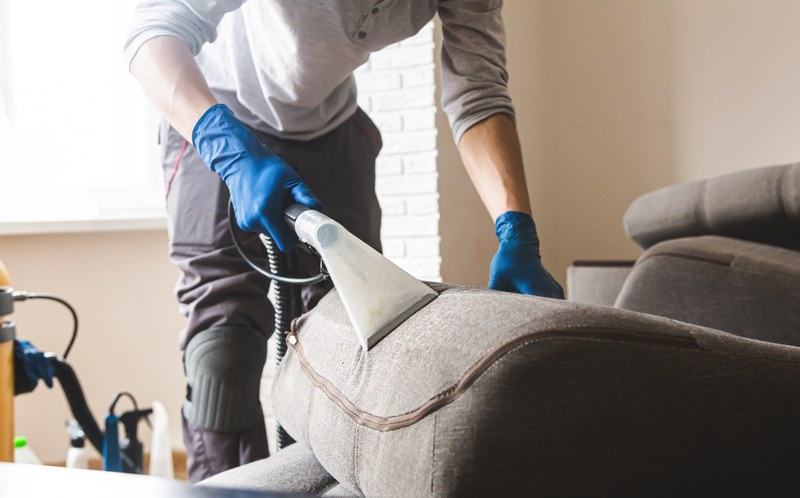 man cleaning a sofa 